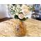 A handmade sunflower vase,  filled with faux daisies and zinnias, decorates a kitchen island. The vase is made from a dried gourd. 